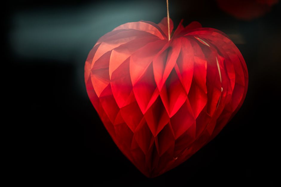 A vibrant red paper honeycomb heart decoration, perfect for romantic themes and Valentine'