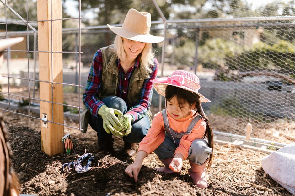A woman and a child engaging in gardening activities outdoors, enjoying quality time toget