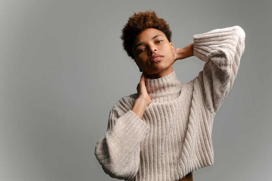 Elegant portrait of a young adult in a textured sweater, photographed in Berlin, Germany.