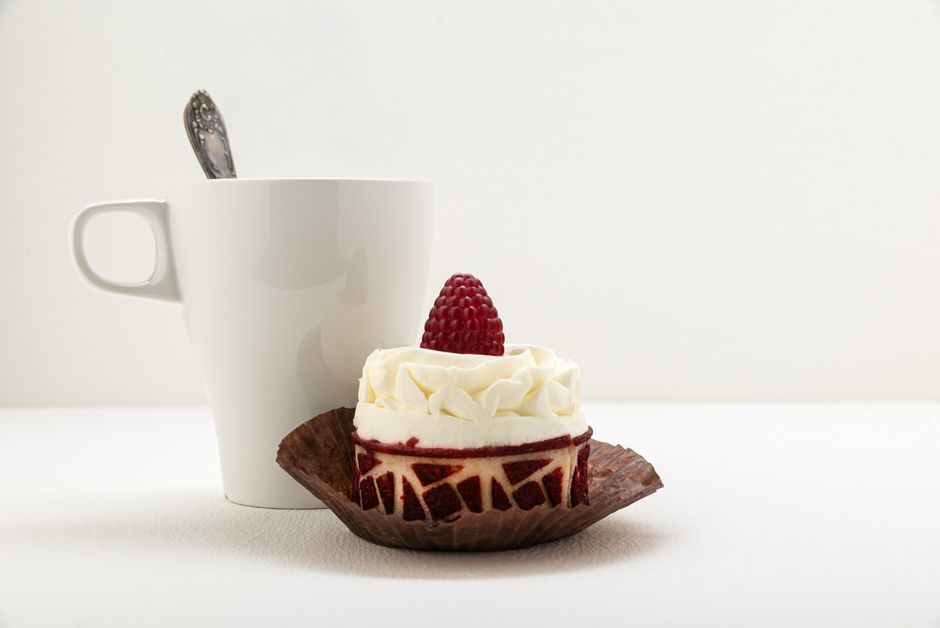 A tempting raspberry-topped cake paired with a steaming mug of coffee.