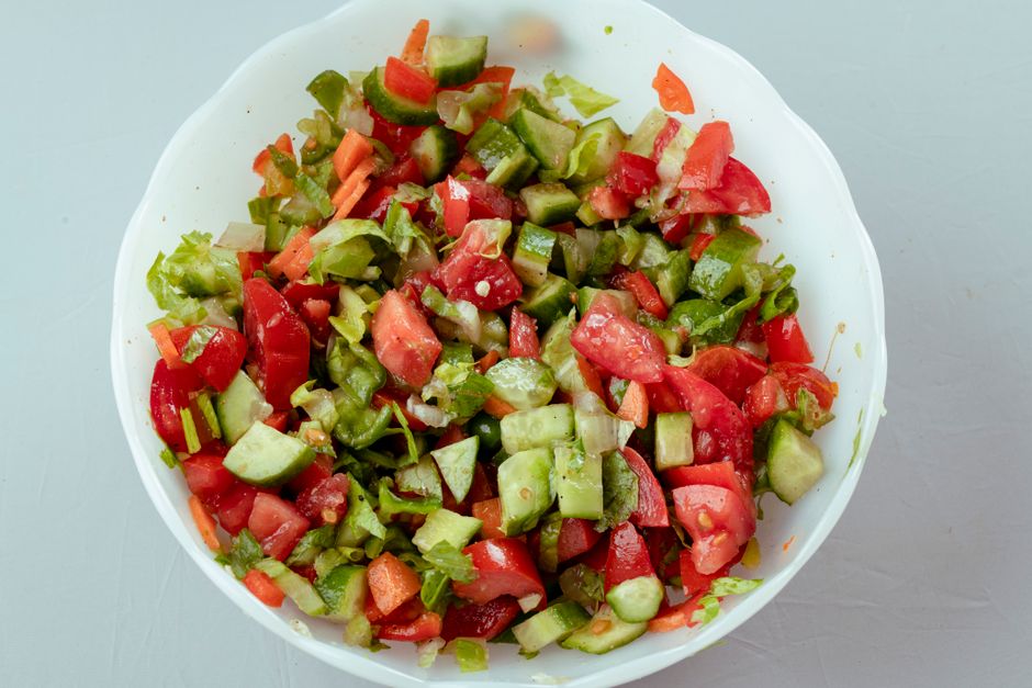 Colorful vegetable salad with tomatoes, cucumbers, and peppers in a bowl. Perfect for a he