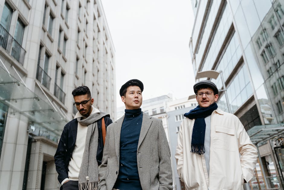 Three stylish men walking in a snowy urban cityscape, dressed in winter clothes.