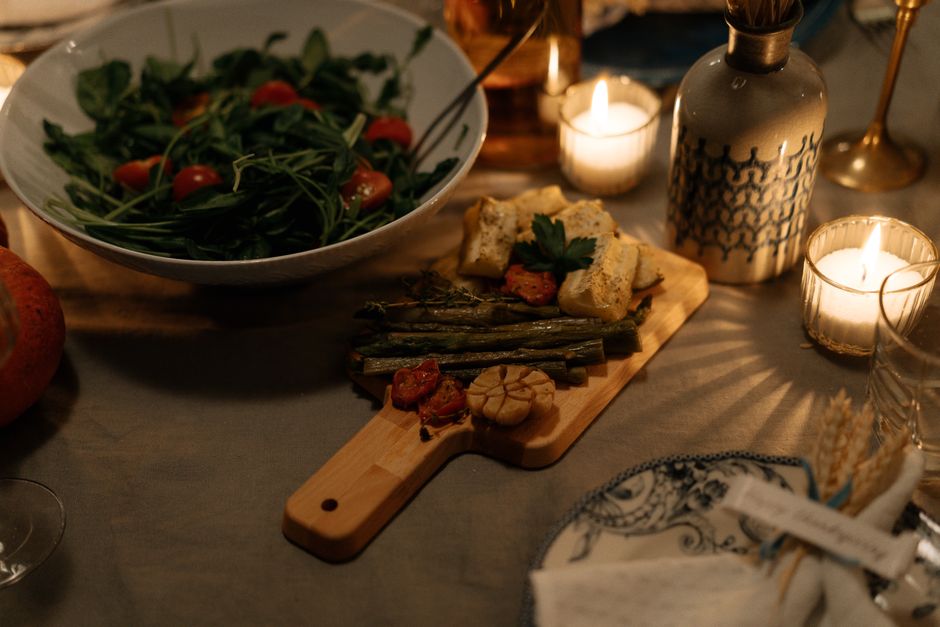 Elegant dinner setting with fresh salad and roasted vegetables in candlelight, perfect for