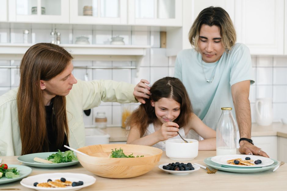 A joyful family moment in the kitchen as parents and daughter share a healthy breakfast together.