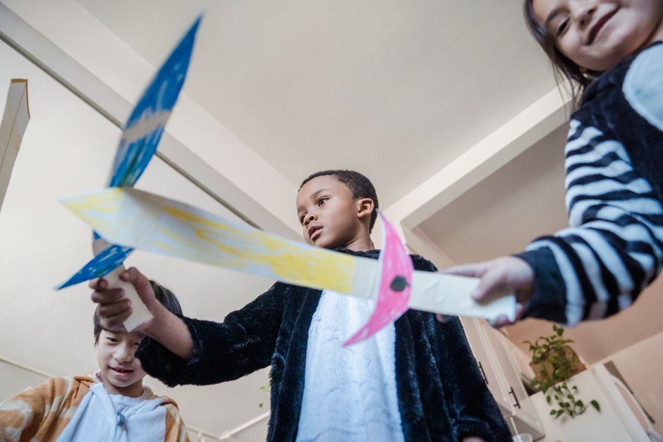 Kids creatively flying paper planes indoors, enjoying a playful moment.