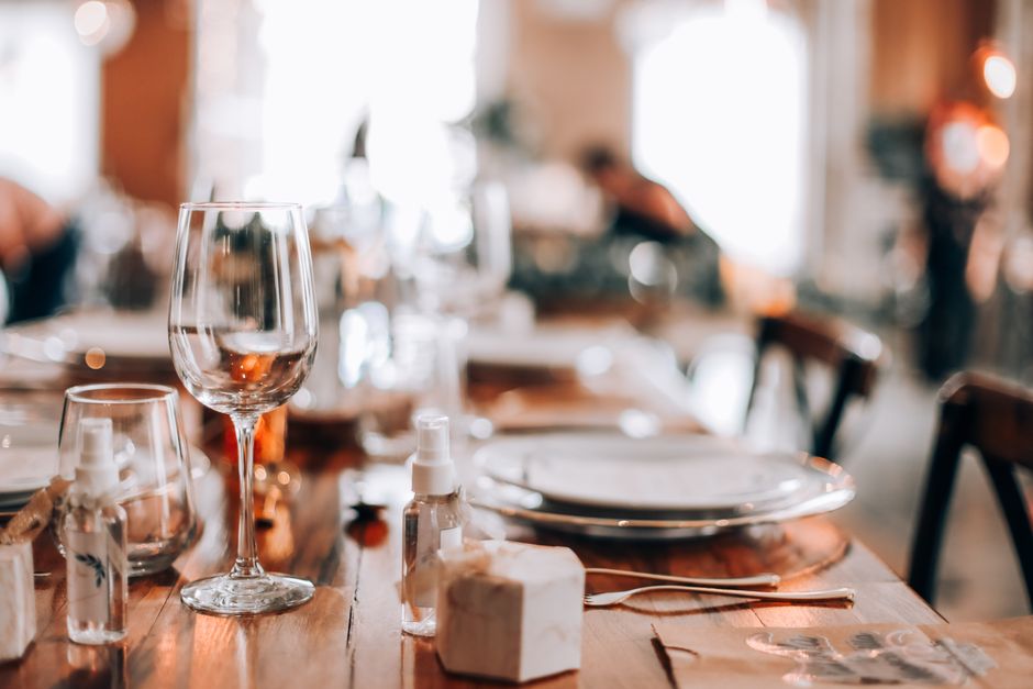 Close-up of elegantly set dining table with glassware and tableware, capturing a warm indoor ambiance.