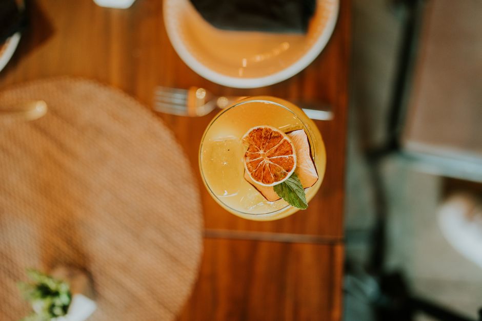 Top view of a refreshing citrus cocktail with mint garnish on a wooden table.